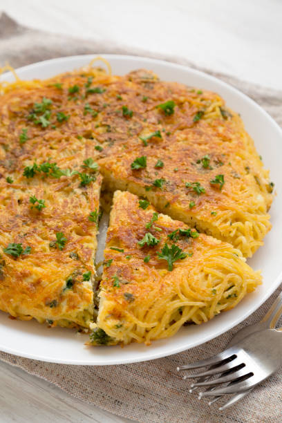 istock Homemade spaghetti omelette on a white plate, low angle view. Closeup. 1187852393