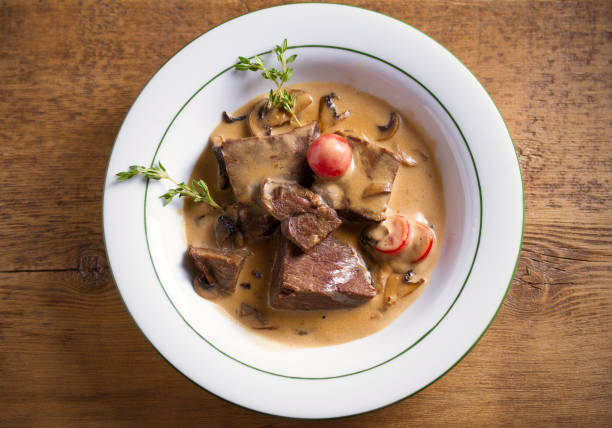 istock Braised beef cheeks in cream sauce with mushrooms and tomatoes 1187853029
