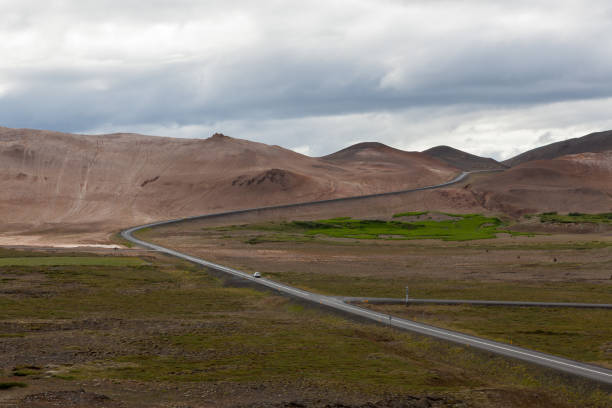 istock Iceland road with brown mountains on the horizon. 1187856219