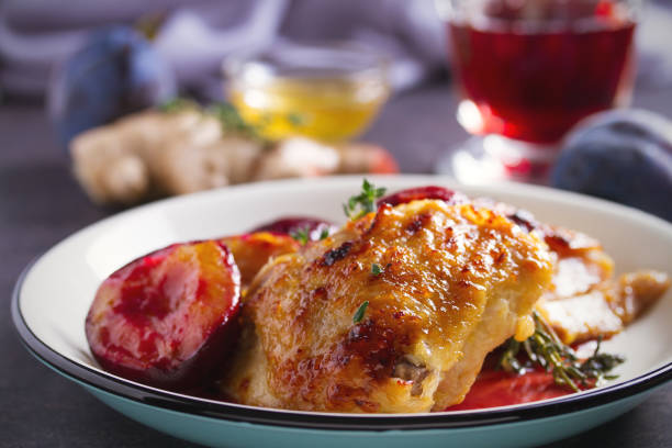 Baked chicken and plums in ginger, honey and red wine sauce with thyme Baked chicken and plums in ginger, honey and red wine sauce with thyme. Horizontal image confit stock pictures, royalty-free photos & images