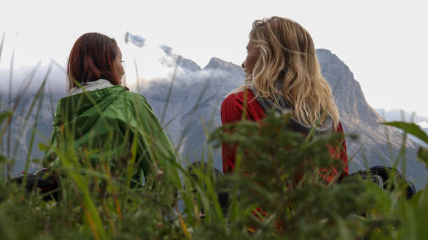 istock Young female hikers relax in grassy meadow 1187858222