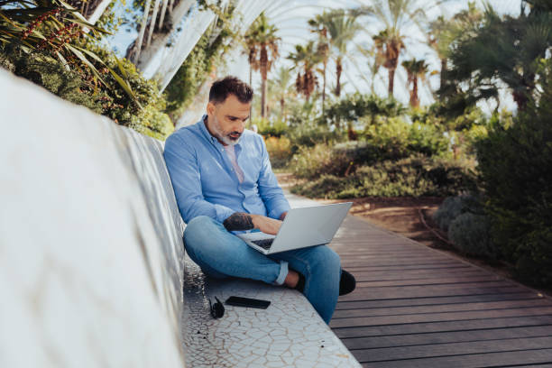 istock Freelancer using the laptop in the park 1187858300