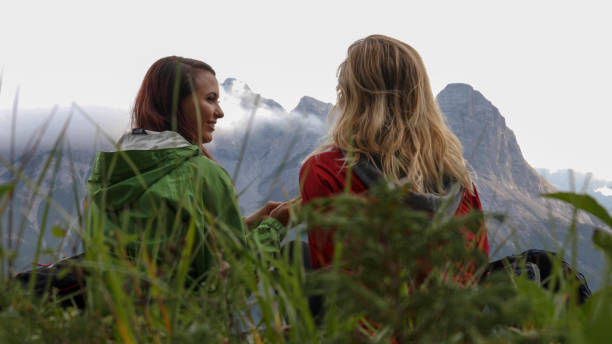 istock Young female hikers relax in grassy meadow 1187858503