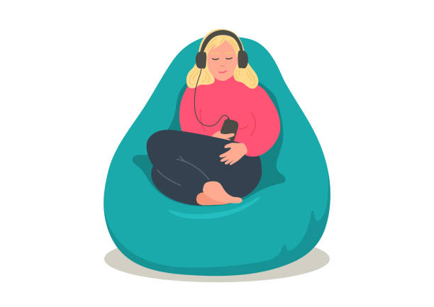 Woman in earphones sitting in comfortable bean bag Woman relaxing  in bean bag and listening podcasts, online training, music, or online radio. Girl in earphones sitting in comfortable armchair. podcasting illustrations stock illustrations