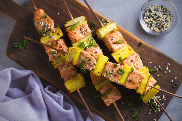 teriyaki de salmón salpicado con puerros, espolvoreado salpicado de semillas de sésamo en tabla de servicio - pink pepper fotos fotografías e imágenes de stock