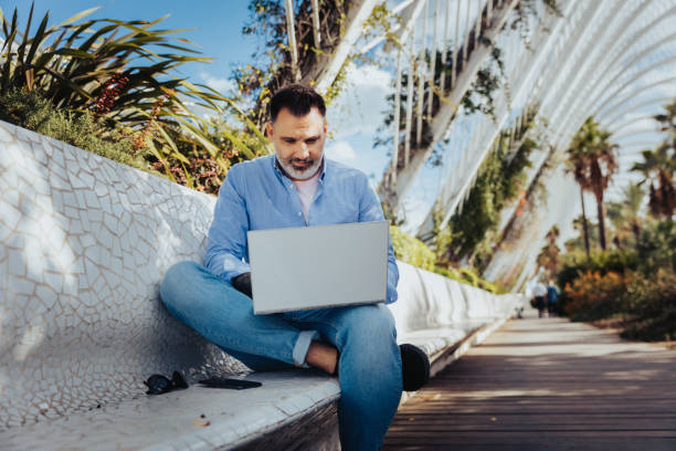 istock Freelancer using the laptop in the park 1187859356