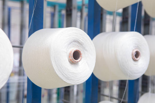 istock Group of bobbin thread cones on a warping machine in a textile mill. Yarn ball making in a textile industry factory. 1187860944