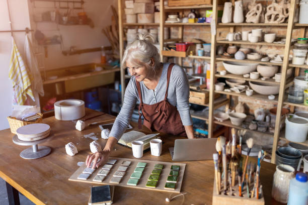 ritratto di artista di ceramiche femminile senior nel suo studio d'arte - potter small business pottery happiness foto e immagini stock