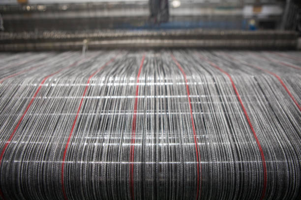 istock Yarn thread lines on the weaving loom machine. A loom machine for clothing or woven label. Weaving machine for garment industry. 1187864573