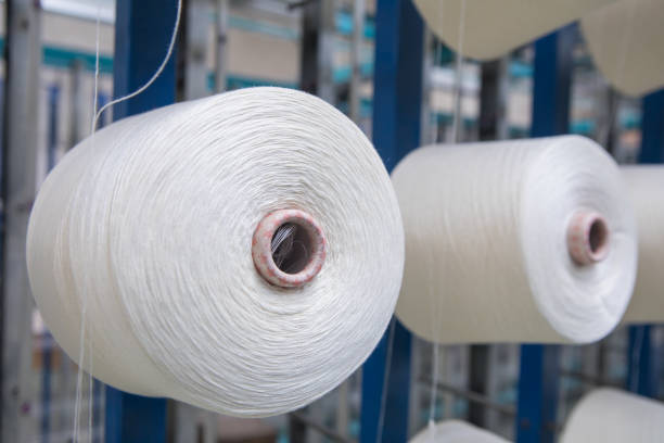 istock Group of bobbin thread cones on a warping machine in a textile mill. Yarn ball making in a textile industry factory. 1187865692