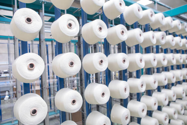 istock Group of bobbin thread cones on a warping machine in a textile mill. Yarn ball making in a textile industry factory. 1187865735
