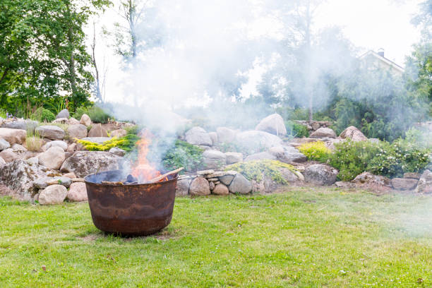 Smoking iron cauldron in a garden in summer