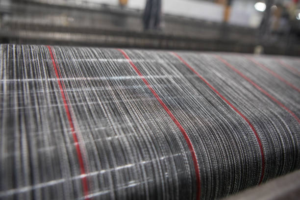istock Yarn thread lines on the weaving loom machine. A loom machine for clothing or woven label. Weaving machine for garment industry. 1187868264
