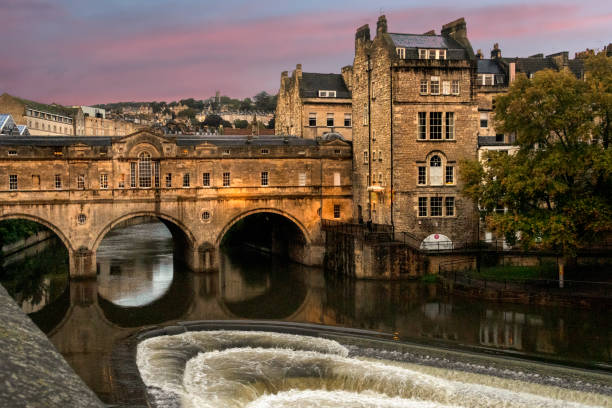 view of downtown Bath, England, with the Pulteney Bridge crossing the River Avon downtown Bath, England, in the late afternoon, showing the River Avon and the old stone Pulteney Bridge crossing it bath england photos stock pictures, royalty-free photos & images
