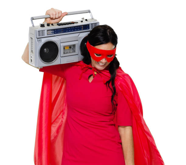 Front view / one person / waist up / portrait of adult beautiful black hair caucasian female / young women superwoman / superhero / heroines / hero dancing / exercising wearing dress / eye mask / mask - disguise / costume / cape - garment who is smiling / happy / cheerful / laughing / joy / listening / conquering adversity / cool attitude who is courage and holding boom box / personal stereo / tape recorder / music / old-fashioned / party - social event vista frontal / una persona / cintura para arriba / retrato de adulto hermoso pelo negro mujer caucásica / mujeres jóvenes supermujer / superhéroe / heroínas / baile héroe / ejercicio usando vestido / máscara de ojos / máscara - disfraz / capa - pre
