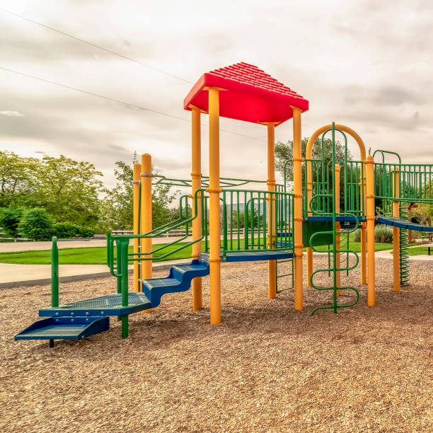 istock Square frame Focus on empty childrens playground at a park with red slides and climbing bars 1187872088