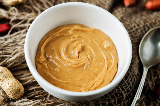 istock Peanut butter with peanuts on a dark wood background 1187872692