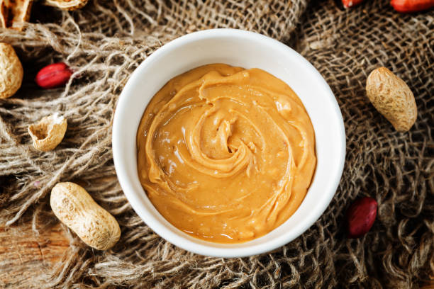 istock Peanut butter with peanuts on a dark wood background 1187872756