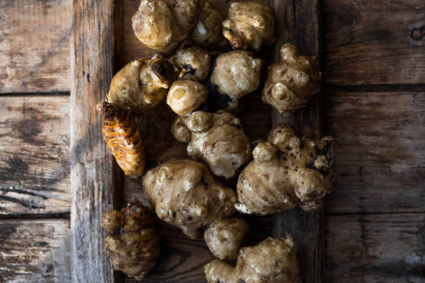 istock Jerusalem artichokes or topinambour, (topinambur), also known as earth apple or sunroot on a cutting board. Dietaryfibre 1187874991