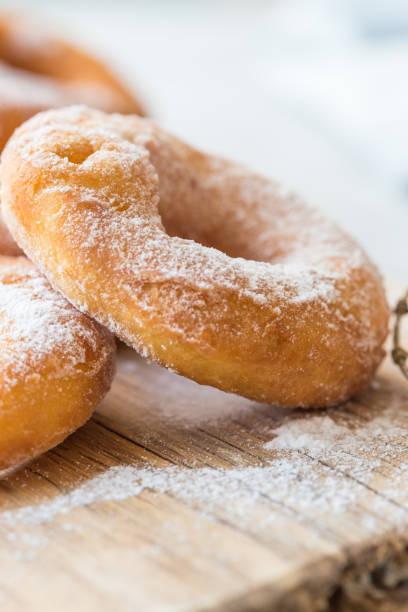 istock Glazed caramel doughnuts. A close up of fresh  doughnuts with sugar powder  in a studio setting. donut 1187874999