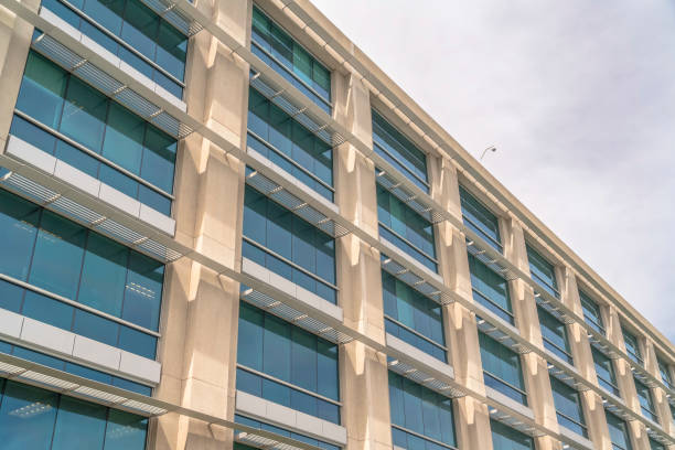 istock Modern building facade close up with glass windows and sunlit concrete wall 1187875049