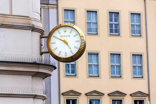 Dresden, Germany - April 1, 2018: Rolex Swiss luxury watch company logo on golden wall clock over the shop on April 1, 2018 in Dresden, Germany.