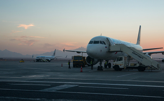 Hurghada, Egypt, the Middle East - November 9, 2015. Passenger planes of the Russian airlines Uralairlines and Orenair are waiting for passengers to load at the airport of Hurghada. Evening photo.