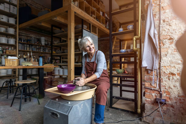 istock Elderly woman making ceramic work with potter's wheel 1187877398