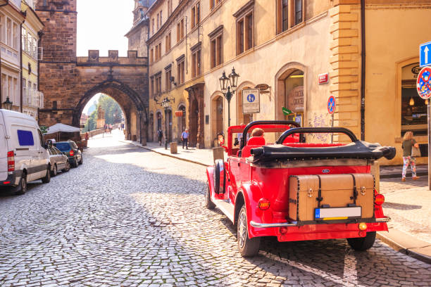 paisaje de la ciudad - vista de un coche vintage y la entrada al puente de carlos, en el centro histórico de praga - classic europe urban scene prague fotografías e imágenes de stock