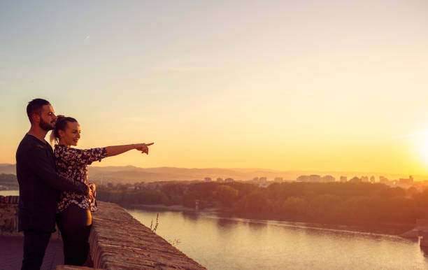 istock Smiling man and woman watching the sunset 1187878945
