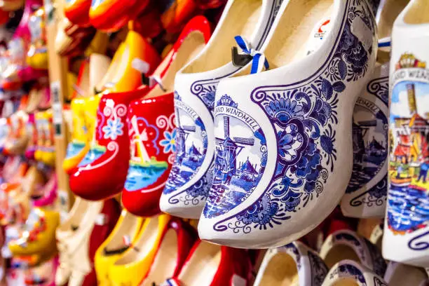 Rack in the store with rows traditional dutch wooden shoes - klompen (clogs), closeup, the Netherlands