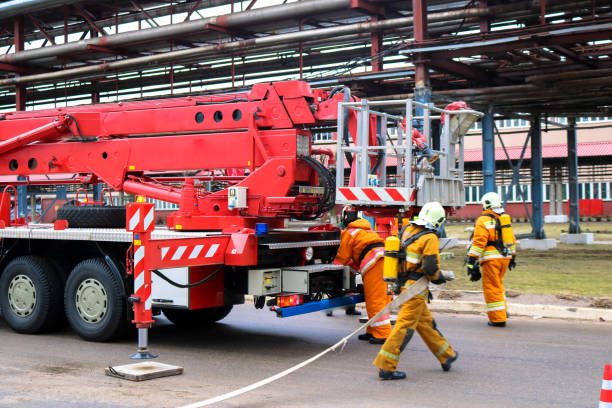 소방차의 화재를 진압하고 파이프와 장비가있는 대형 산업 공장에서 호스를 스트레칭하기 위해 온 소방관 구조 대원 - engine car truck hose 뉴스 사진 이미지