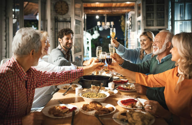 family having thanksgiving dinner. - wine dinner party drinking toast imagens e fotografias de stock