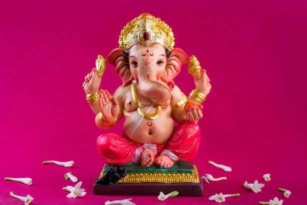 Photo of Hindu God Ganesha. Ganesha Idol on pink background.