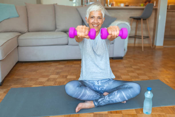 istock Senior lady smiling at the camera whilst using dumbbells. 1187885552