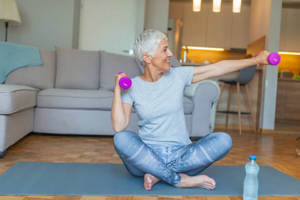 istock Senior lady smiling at the camera whilst using dumbbells. 1187885655