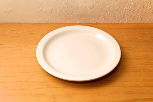 istock empty ceramic plate on wooden counter against wall 1187888207