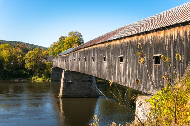 istock Historic covered bridge over a river on a clear autumn day 1187889306
