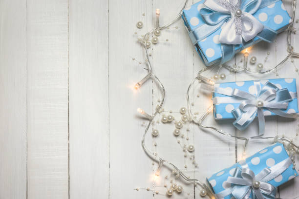 istock Blue gift boxes and lights with pearls on white wooden background 1187890814