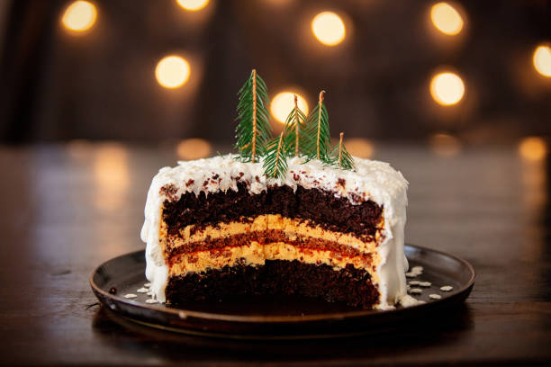 istock Christmas cake with cream on table with fairy lights 1187891661