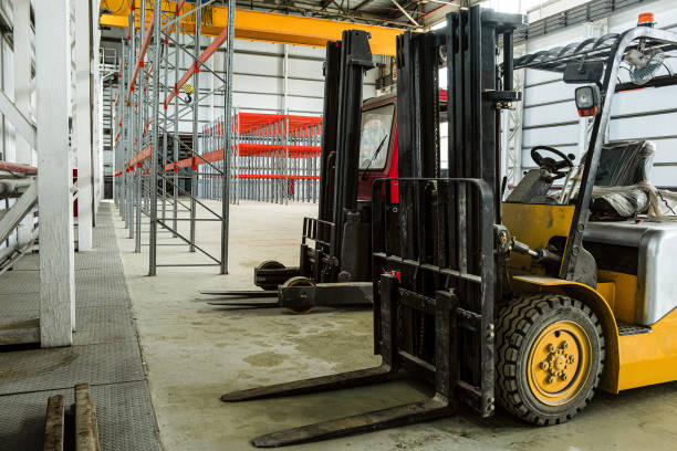 istock Forklift trucks in a industrial warehouse building 1187891854