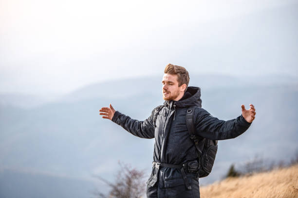 istock Young hiker standing with arms open on the mountain top. 1187897178