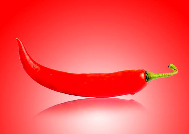 istock Chili pepper isolated on red white, reflecting background.Ripe chili pepper Clipping Path 1187897932