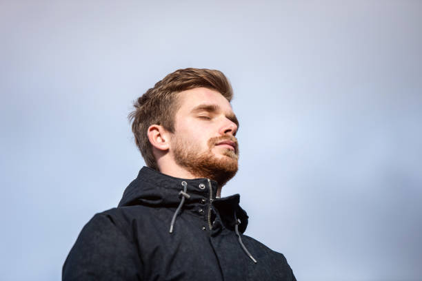 istock Low angle view of young man meditating outdoors on a cold day. 1187897991