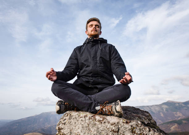 istock Young man meditating on mountain top. 1187898078