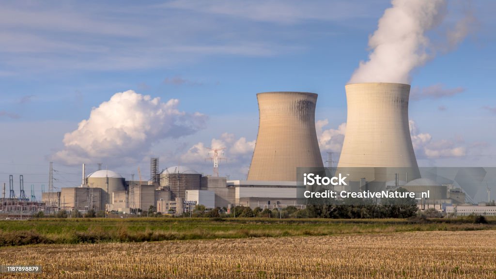 Nuclear power plant with cooling towers Nuclear power plant with steaming cooling towers under blue summer sky in Belgium Nuclear Power Station Stock Photo