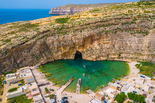 The Inland Sea and tourist boat. Dwejra is a lagoon of seawater on the island of Gozo. Aerial view of Sea Tunnel near Azure window. Mediterranean sea. Malta country