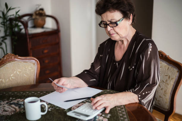 istock Old woman with eyeglasses doing calculations 1187907485
