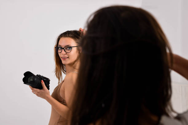 istock A young posing woman in the studio doing a commercial for a camera 1187907550
