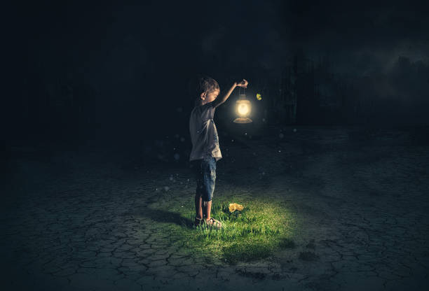 Lost child holding an old lamp in an apocalyptic environment stock photo